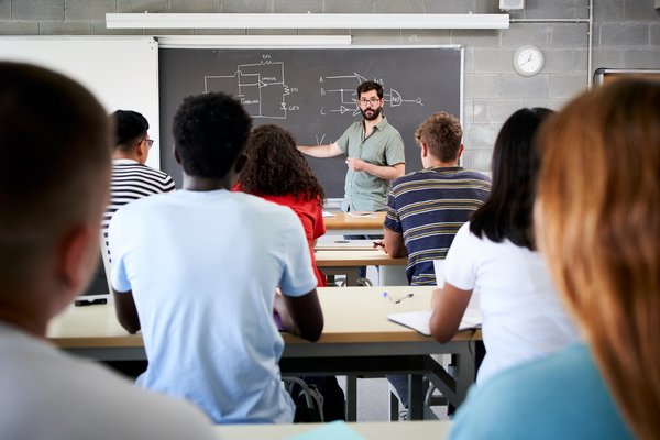 male-tutor-teaching-university-students-in-classro-2023-11-27-05-16-59-utc